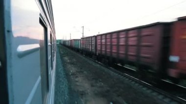 Hareket eden bir trenin çekim. Komşu tren geçen yük treni üzerinde ters yönde.