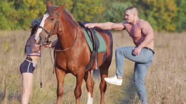 Young Man Strong Physique Climbs Horse Young Slender Woman Holding — Stock Video