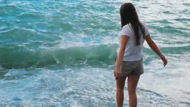 Девочка весело играет с волнами удивительного моря — стоковое видео