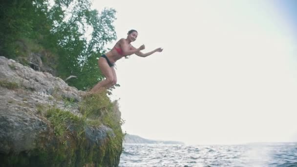 Chica haciendo un truco en el salto en el agua, cámara lenta — Vídeos de Stock