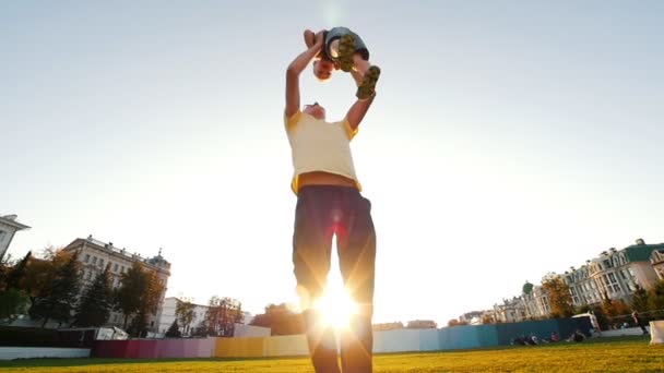 Mann, junger Vater hält seinen Sohn und wirbelt ihn im Sommer im Park in die Luft — Stockvideo