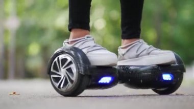 Parkta bir gyro sürme kendi ekseni etrafında bir çember içinde serin spor ayakkabı kız