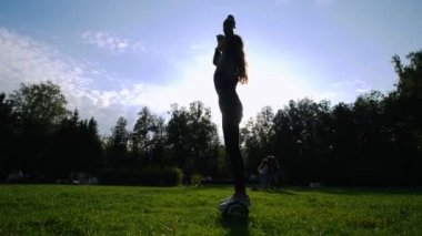 Genç kız parkta, çimlerin üzerine bir gyro tesisi onun saçını çekerek yakın çekim