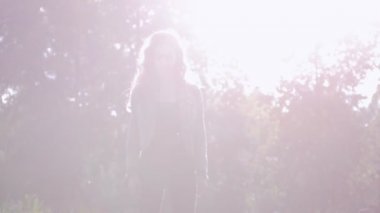 Genç kız parkta çim üzerinde bir gyro sürme. Oyun ışık. Güneş parlamayı.