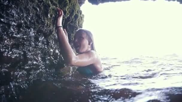 Young woman swims in sea on grotto cave, slow motion — Stock Video