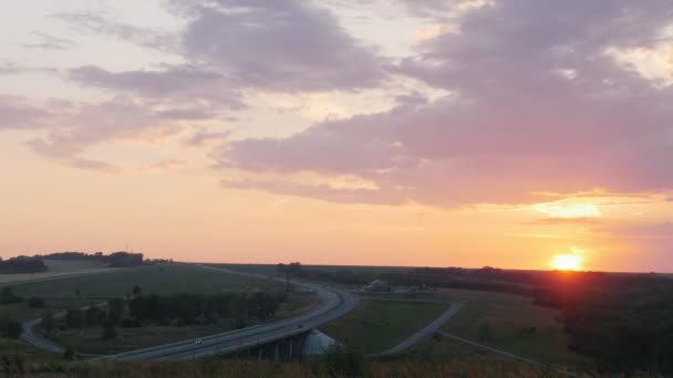 Charakter. Piękny zachód słońca. Dolina. Na drodze przejeżdżających samochodów — Wideo stockowe