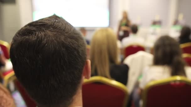 Rear view of young man sitting at the business conference — Stock Video