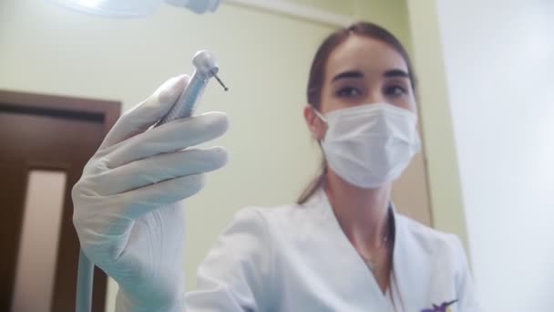 女性歯科医が歯科イルリガートル ツールを保持、オンします。歯科医のオフィス — ストック動画