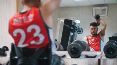 Tekerlekli sandalyeli Engelli yakışıklı halter salonunda eğitim sırasında presler.