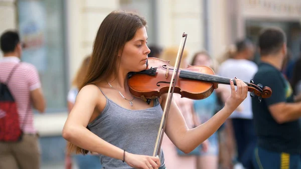 Молодая девушка играет на старинной скрипке на природе — стоковое фото