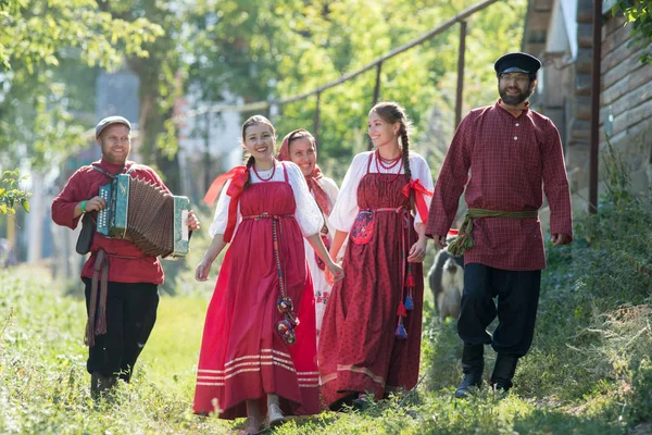 Μια ομάδα νέων ανθρώπων στη Ρωσική εθνικές ενδυμασίες, το περπάτημα γύρω από το χωριό — Φωτογραφία Αρχείου