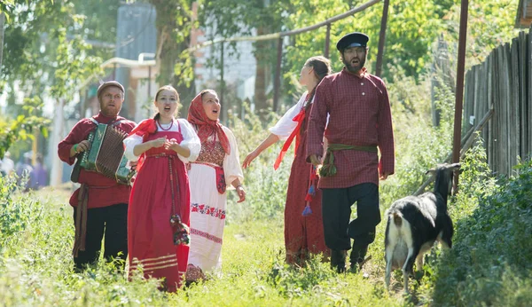 Grupo de homens e mulheres em trajes populares russos na natureza cantando. Celebração — Fotografia de Stock