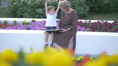 Büyükannesi ile birlikte bir kitap okuma torunu