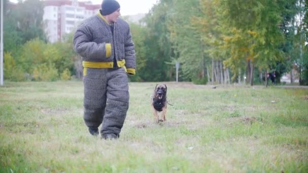 Um homem a fugir do cão, o cão corre atrás dele. a correr para a câmara. câmara lenta — Vídeo de Stock