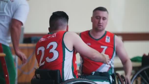 Kazan, Rússia - 21 de setembro de 2018 - Jogadores de basquete com deficiência em cadeira de rodas apertam as mãos durante o jogo no ginásio — Vídeo de Stock