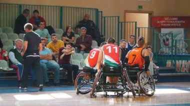 Kazan, Rusya Federasyonu - 21 Eylül 2018 - Engelli oyuncu tekerlekli tekerlekli bir takım arkadaşı için tekerlekli sandalye basketbol spor salonunda bir oyun sırasında onarır