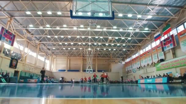 Kazan, Oroszország - 2018. szeptember 21. - fogyatékkal élők játékos dob a labdát a kosárba, a játék során a Kerekesszékes kosárlabda az edzőteremben — Stock videók