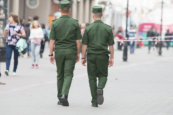 Two soldiers in uniform walking down the street back to camera — Stock Photo, Image