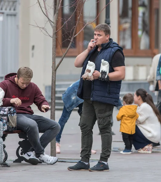 Kazan, Rusland - 27 augustus 2018 - Man met hand duiven is staande op de straat en roken — Stockfoto