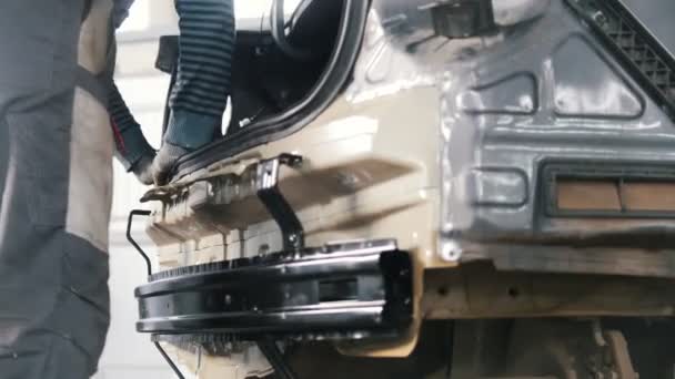 Механик проверяет надежность кузова автомобиля в автомастерской — стоковое видео