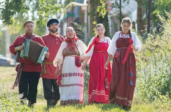 Группа мужчин и женщин в русских народных костюмах на природе. Праздник — стоковое фото
