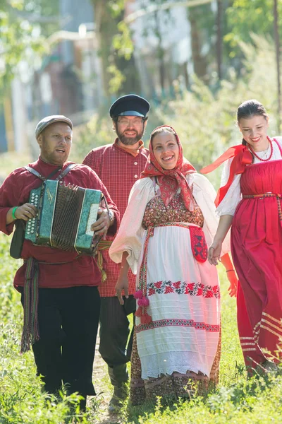 Группа мужчин и женщин в русских народных костюмах на природе. Улыбаюсь. Праздник — стоковое фото