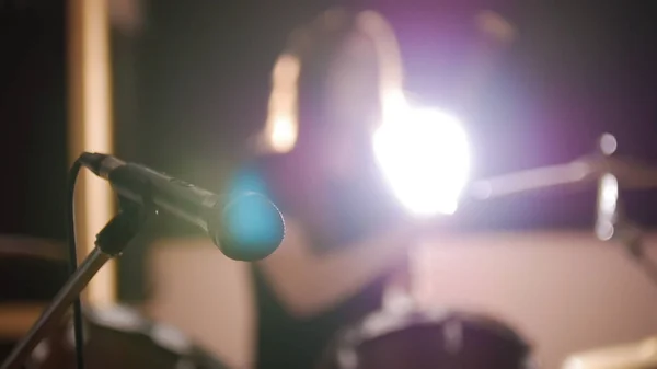 Chica pelirroja practicando sobre un tambor en una habitación oscura — Foto de Stock