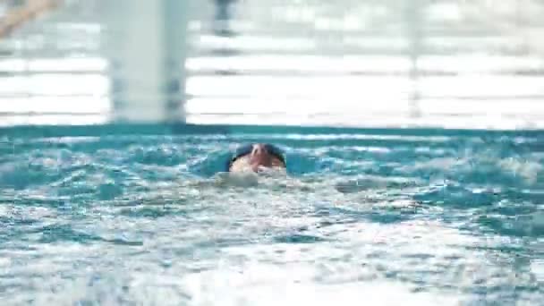 Gehandicapte man zwemt op de rug in een zwembad. De vlinderslag. — Stockvideo