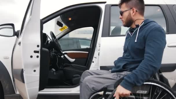 Hombre discapacitado en silla de ruedas se sube al coche — Vídeos de Stock