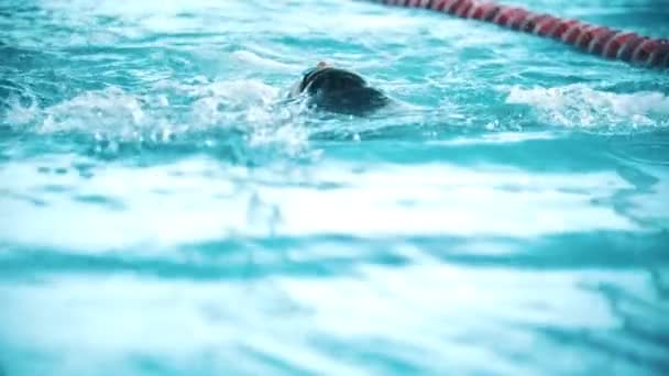 O homem com deficiência nada nas costas numa piscina. Movimento lento — Vídeo de Stock