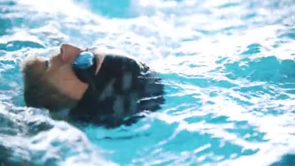 Disabled man swims on the back in a swimming pool. Close up shot. Slow motion — Stock Video