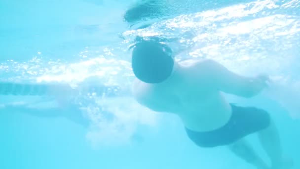 Disabled man swims on the back in a swimming pool. Underwater shot — Stock Video