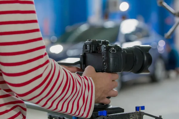 Vestite con strisce a maniche lunghe fotografi mani stanno tenendo una fotocamera su uno sfondo sfocato — Foto Stock