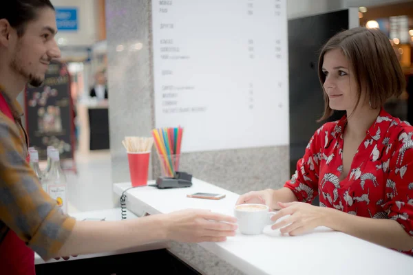 Kunden får en order från händerna på en leende barista — Stockfoto