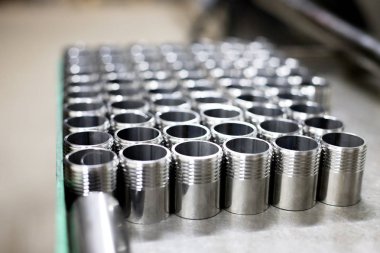 Parlak metal parçalar üzerinde fabrika bir torna ile oluşturulan iş parçacığı ile satırları