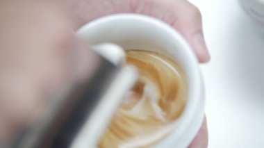 Barista latte kahve dökülen ve güzel bir resim oluşturur