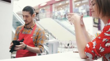 Onun bu işle ve müşteri gülümseyen kafede barista kahve içer