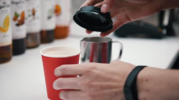 Barista cierra una taza de papel con una tapa superior — Vídeo de stock