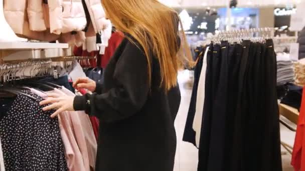 Menina bonita andando ao redor do shopping e procurando uma roupa — Vídeo de Stock