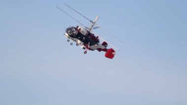 Kırmızı-beyaz helikopter kadar uçar ve ters yönde dönüyor