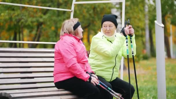 Due donne mature riposano dopo una passeggiata scandinava — Video Stock