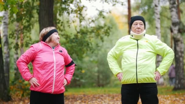 Reife Frau in bunten Jacken steht nach dem Turnen — Stockvideo