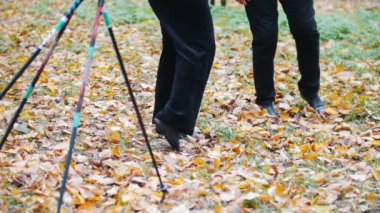 Olgun kadın bir sonbahar park içinde jimnastik yapıyor. Ayak