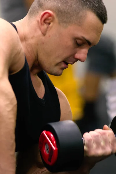 Сильна людина накачує м'язи. М'язистий культурист робить вправи в тренажерному залі . — стокове фото