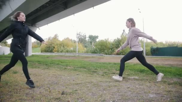 Jovens meninas acrobáticas realizando acrobático split enquanto saltando — Vídeo de Stock