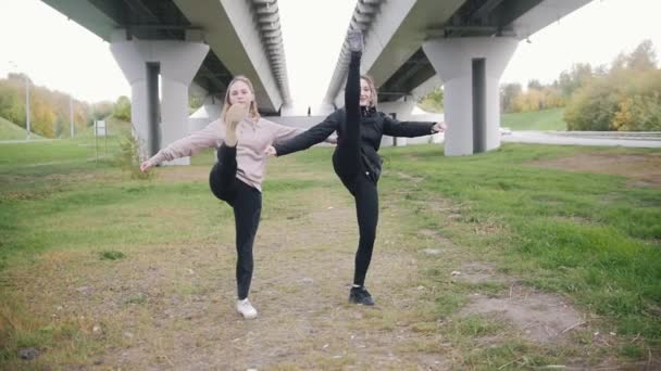 Akrobatické dívky jít směrem kamery, zachycující jejich strečink — Stock video