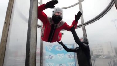 Aerodinamik tüp. Rüzgar kişi kaldırdı. Onu tutan eğitmen