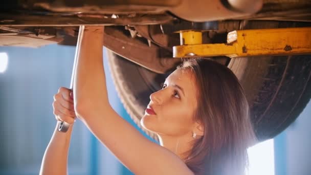 Sexy dívka mechanik oprava auto s klíčem. Detailní záběr — Stock video