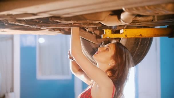 Sexy dziewczyna mechanik naprawia auto z klucza. Kąt boku — Wideo stockowe