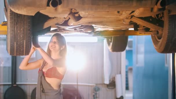 Σέξι κορίτσι μηχανικός, επισκευή ενός αυτοκινήτου με ένα κλειδί, φωτεινός φωτισμός — Αρχείο Βίντεο